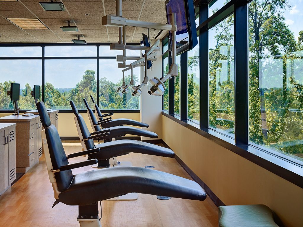 a row of dental chairs in front of a window wall