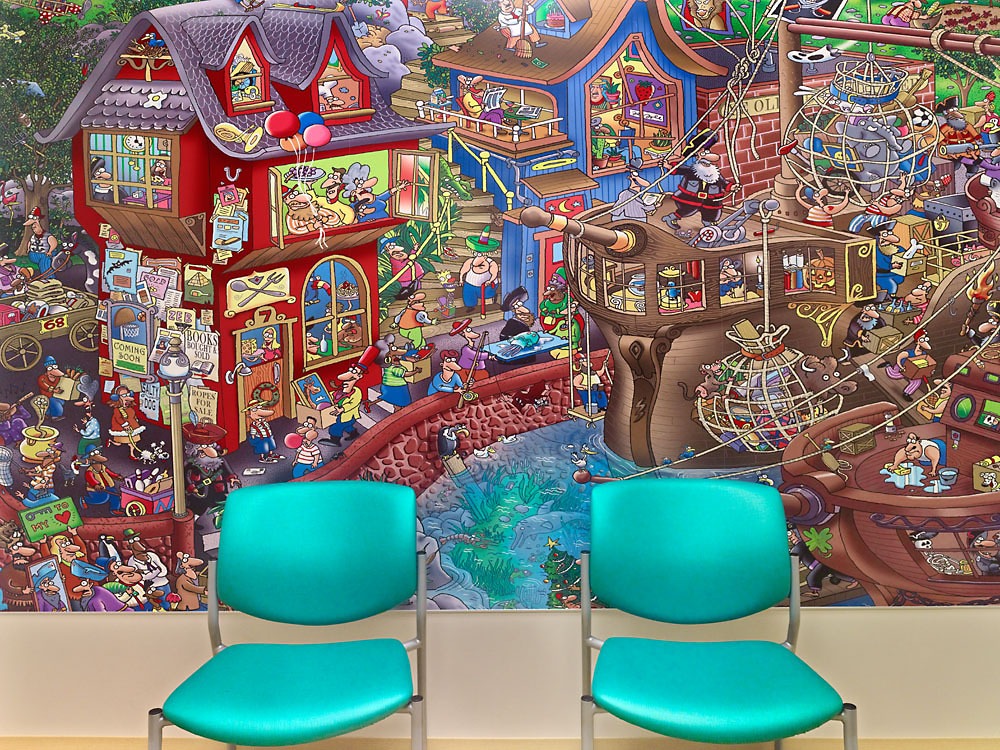 two blue chairs sitting in front of a detailed pirate cartoon mural
