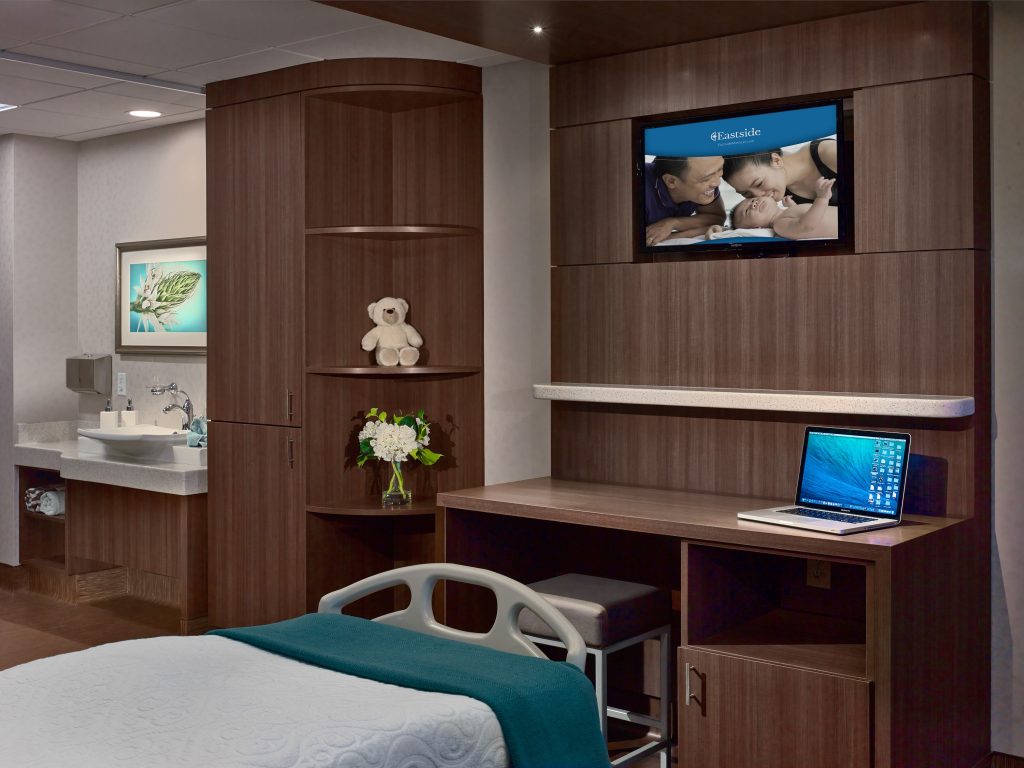 Eastside Women's care room view with wood accent walls, modern fixtures and decor