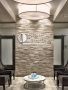 waiting room with water bottles on a central coffee table and a textured accent wall featuring Premier Image's logo