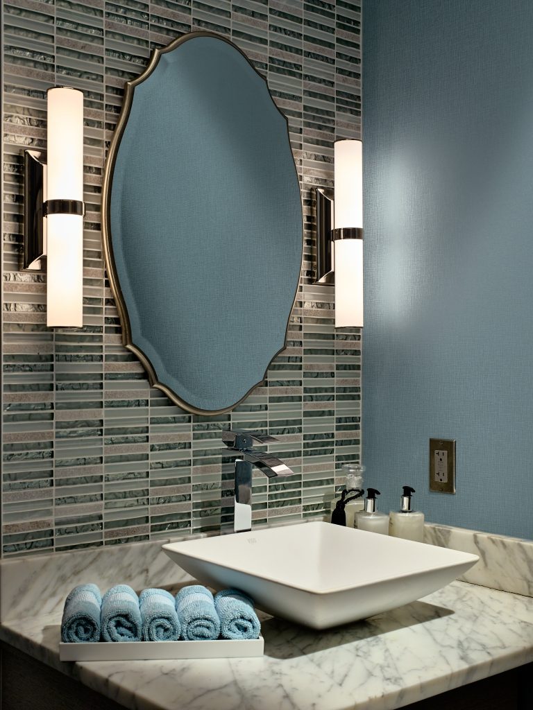 bathroom counter with two accent lights, complimentary towels and a raised sink