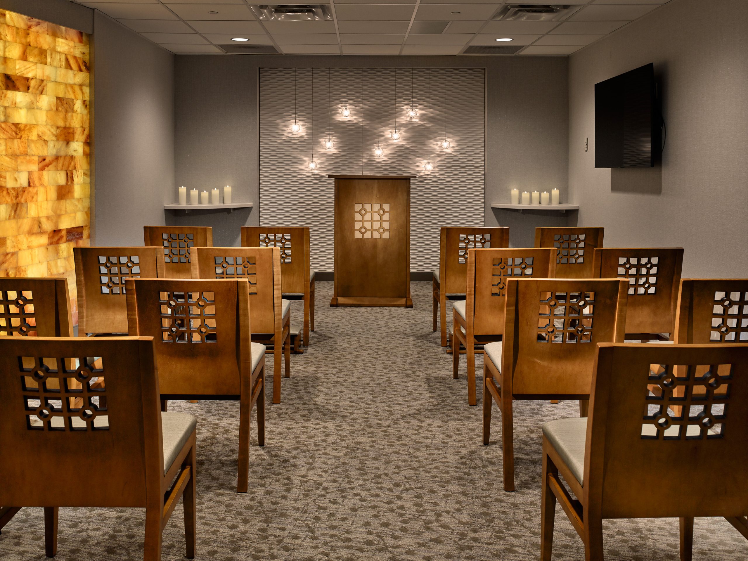 Full view of Chapel at Wellstar Cobb Hospital with a podium, seating, an accent wall, and candles