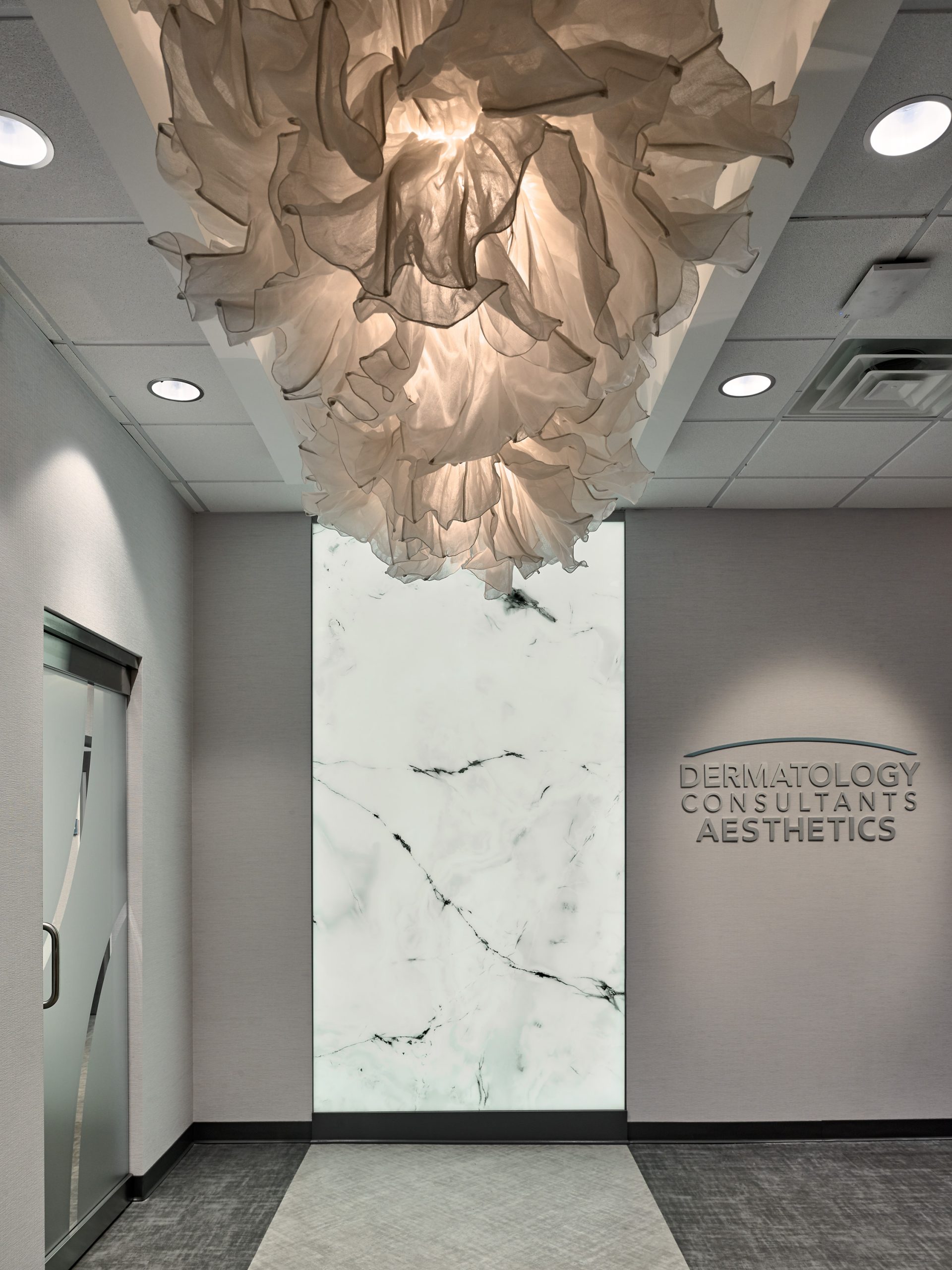 Unique chandelier and accent marble wall in Dermatology Consultants office
