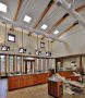 an open dental office with central cabinets and a high ceiling with hanging TVs