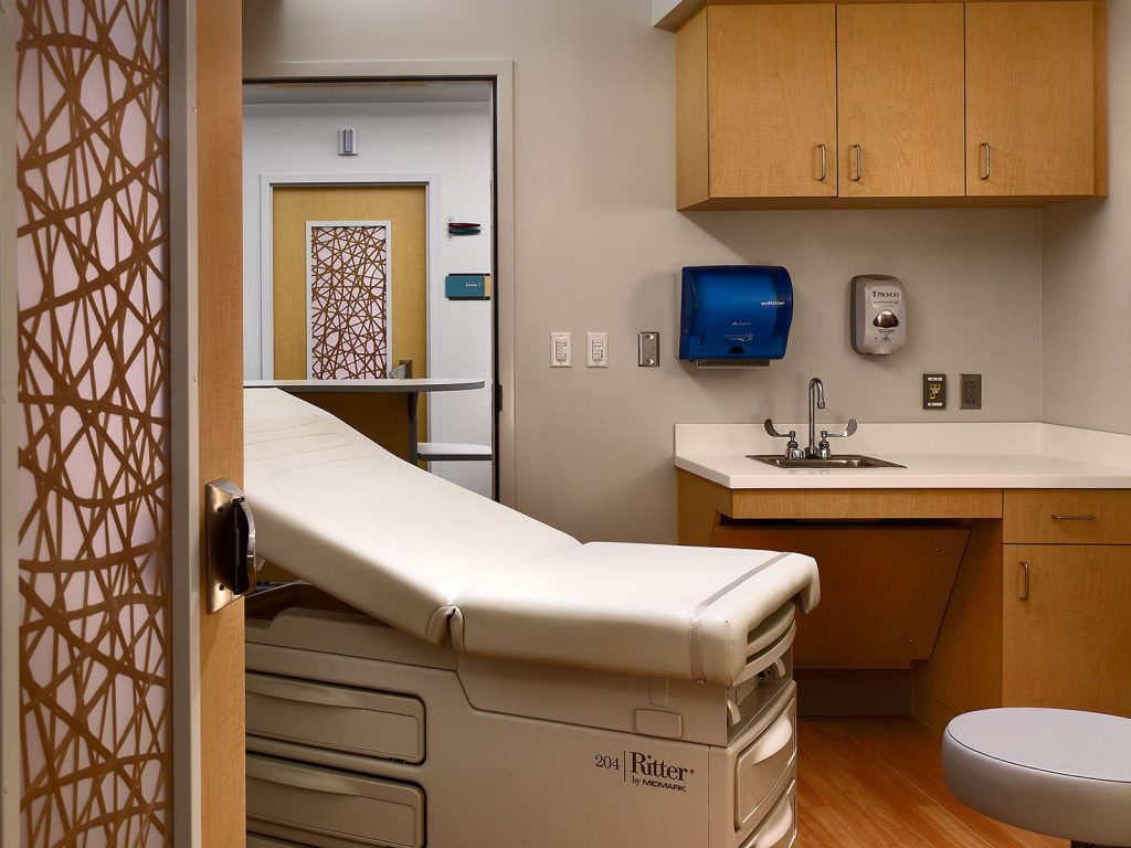 Full view of Kirkland Cancer Center examination room with warm wood accents