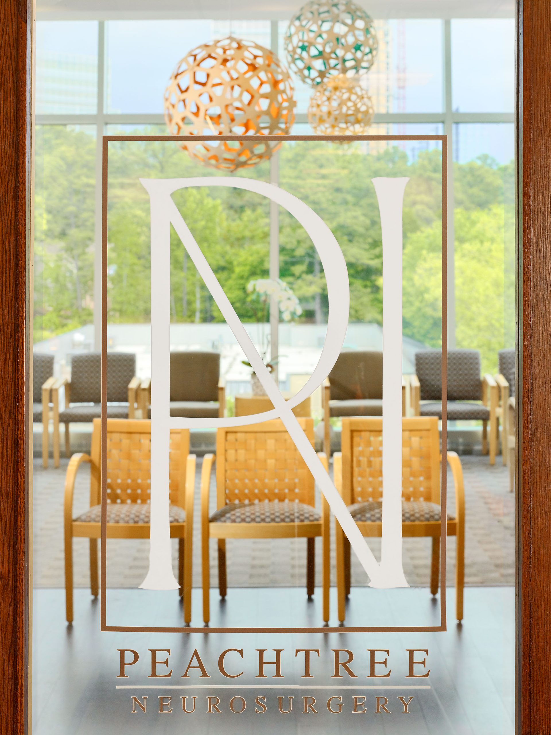 Peachtree Neurosurgery glass logo door with a view of a waiting room behind