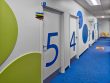 Roswell Pediatrics hallway with blue carpet and large accent numbers on exam rooms
