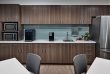 breakroom kitchen with stainless steel appliances, dark wood cabinets and a light blue accent wall