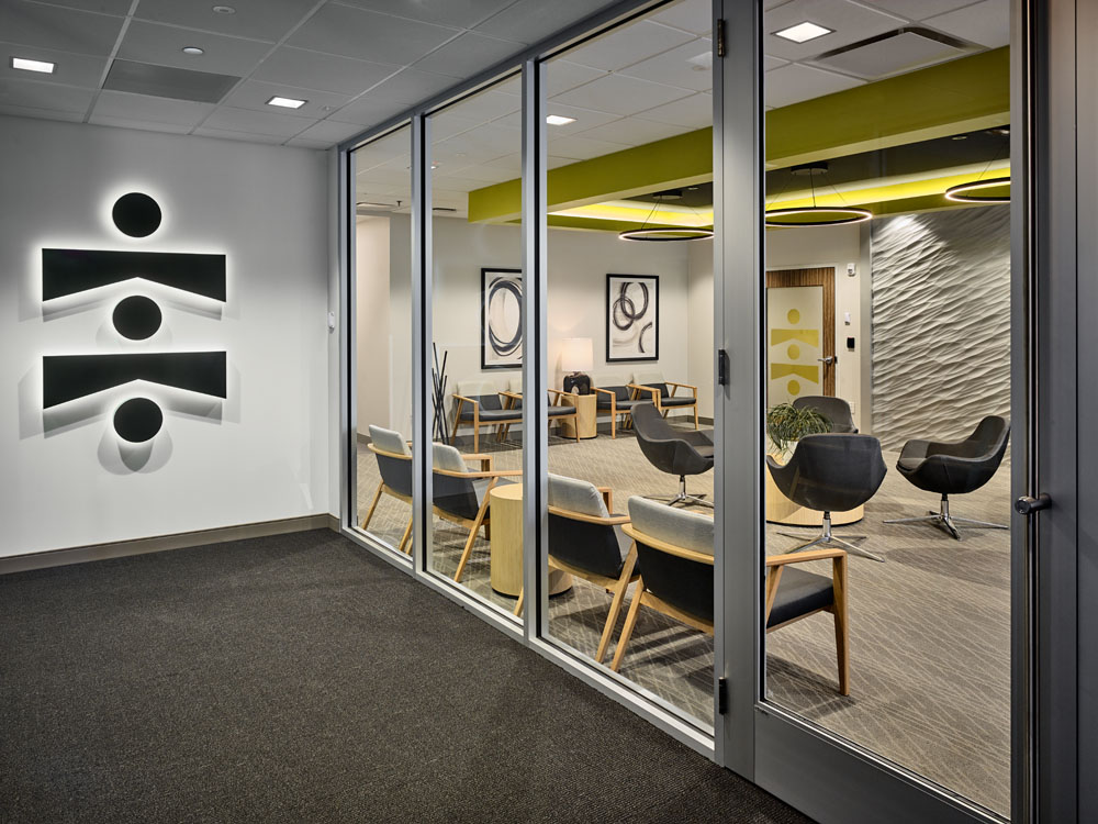 Axion Spine and Neurosurgery logo wall with a view through glass doors into a waiting room